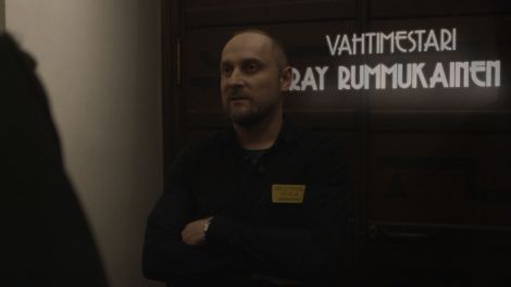 Graafikko Uolevi Holmbergin luoma grafiikka haastateltavan taakse.